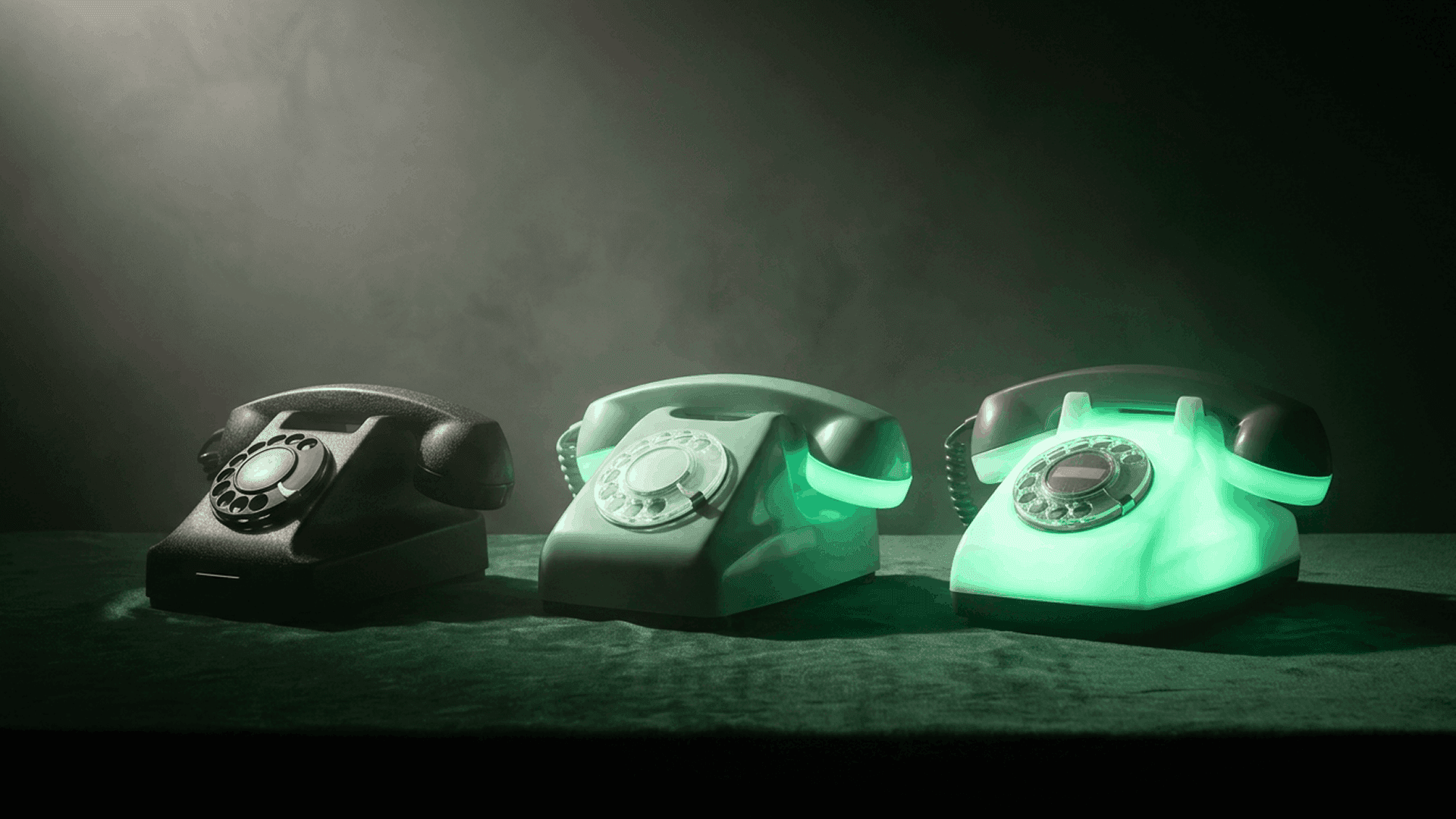 Cinematic product render of three vintage rotary telephones on a deep green velvet surface, progressing left to right from matte black to pale gray to fully glowing mint green, representing the capability progression from IVR to live agent to AI voicebot for healthcare patient access