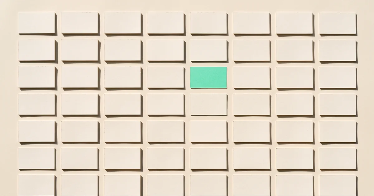 One standout card in a grid Grid of blank cream cards in even rows on a cream surface with one mint green card standing out near the center