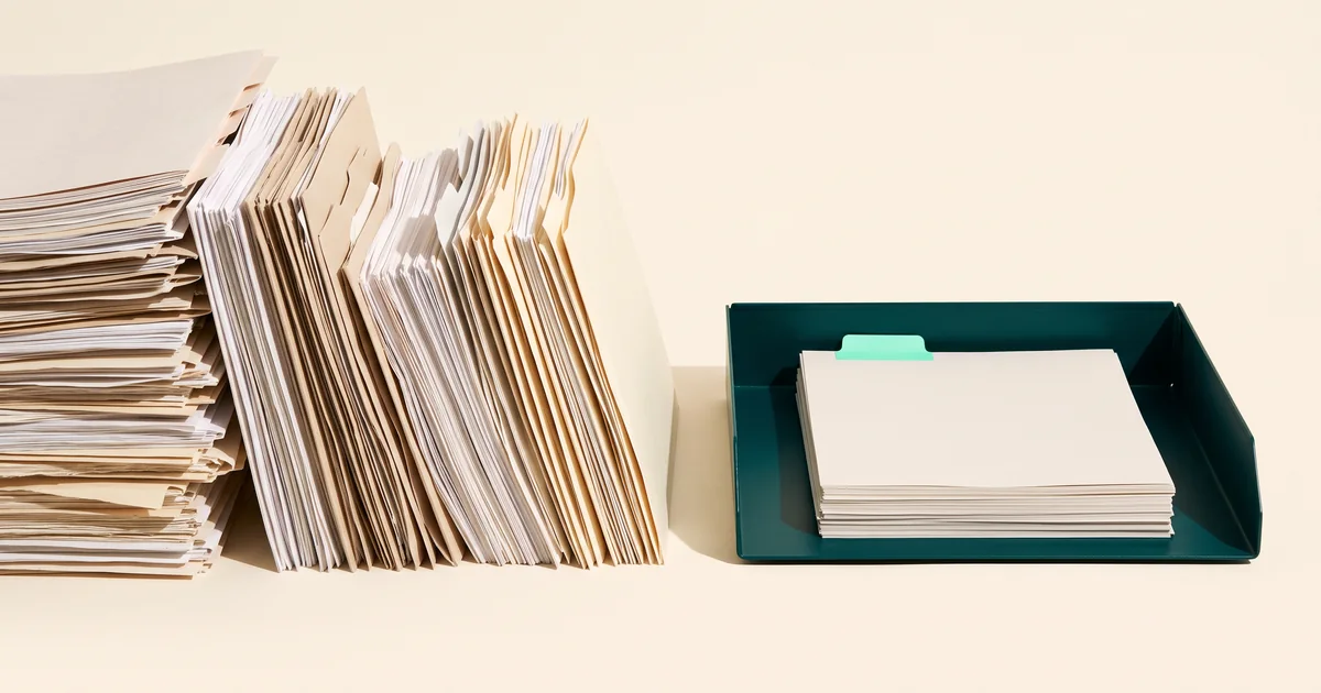 Many payer files becoming one worklist Tall stacks of worn manila folders beside a dark green tray holding one neat stack of pages with a single mint tab